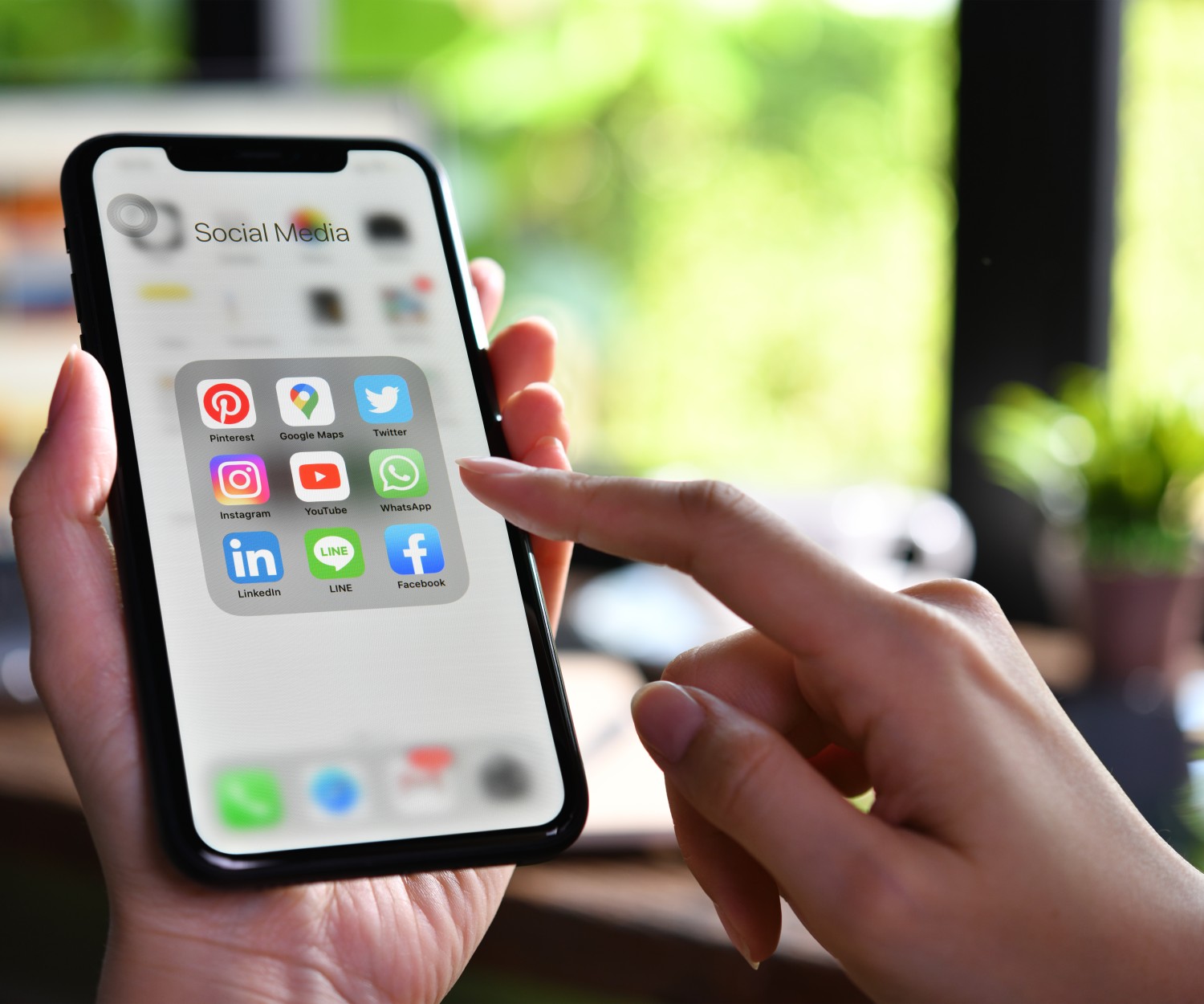 BANGKOK, THAILAND - MARCH 30,2020: Female holding Iphone xr with icons of social media on the screen at the coffee shop.